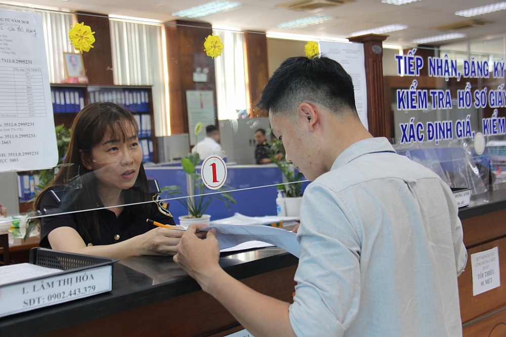 Công chức chi cục HQ Cái Mép  (Cục Hải quan Bà Rịa Vũng Tàu) hướng dẫn thủ tục cho DN. 	Ảnh: Nguyễn Hiền 