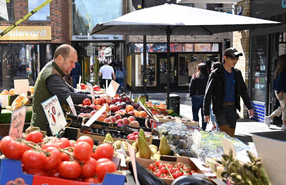 Người dân mua sắm tại một chợ ở London (Anh). (Ảnh: AFP/TTXVN)