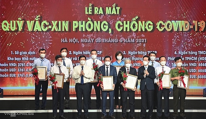 Lãnh đạo Đảng, Nhà nước tiếp nhận đóng góp của các bộ ngành, địa phương tại lễ ra mắt Quỹ Vaccine Covid-19.	Ảnh: ST