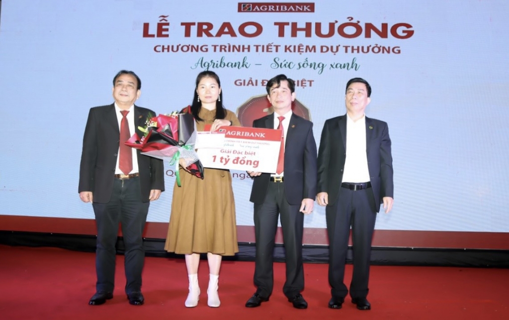 Ban Lãnh đạo Agribank chi nhánh Bắc Quảng Bình chụp ảnh cùng Khách hàng Trương thị Hương Hoa.